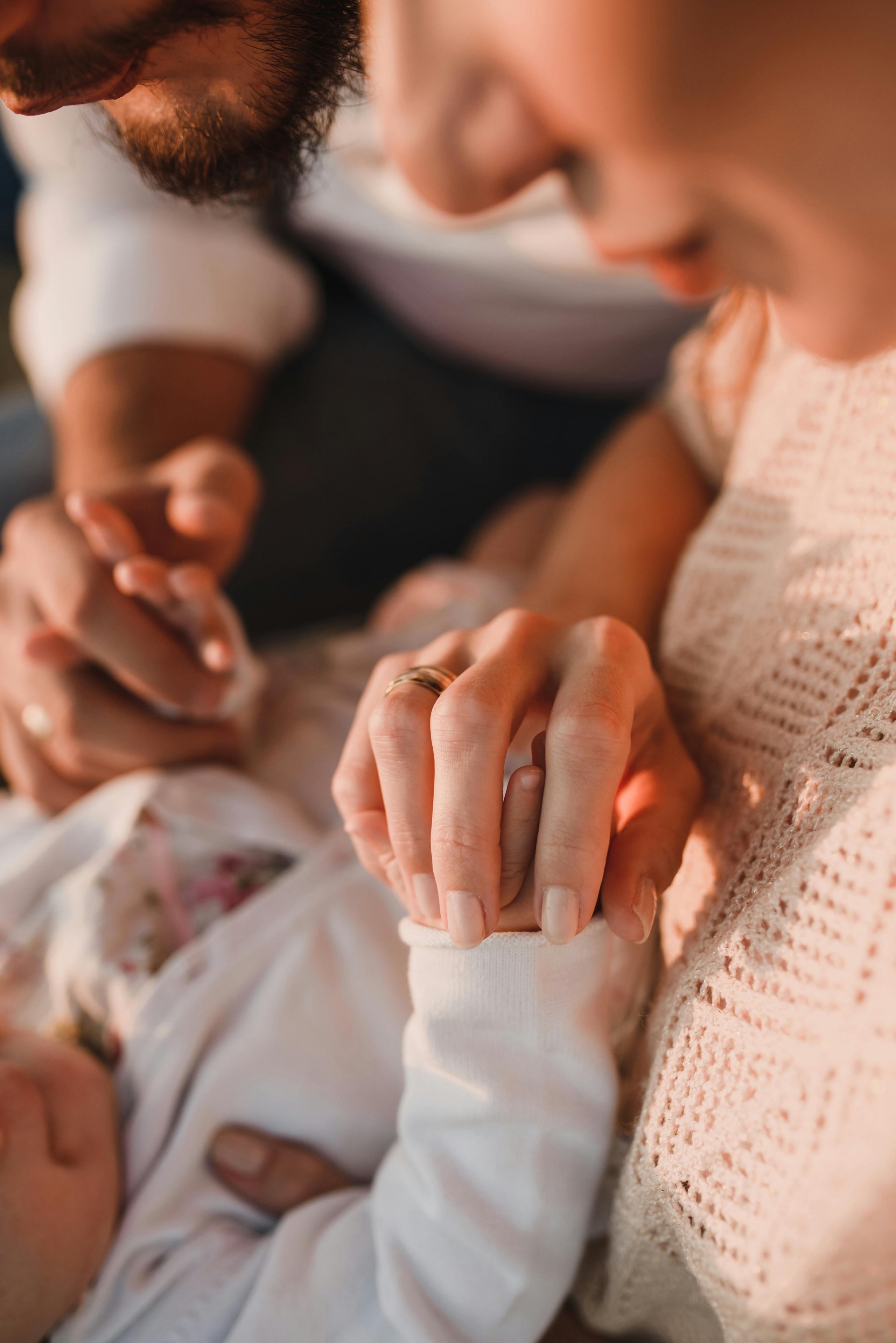Parents holding their newborn's hand