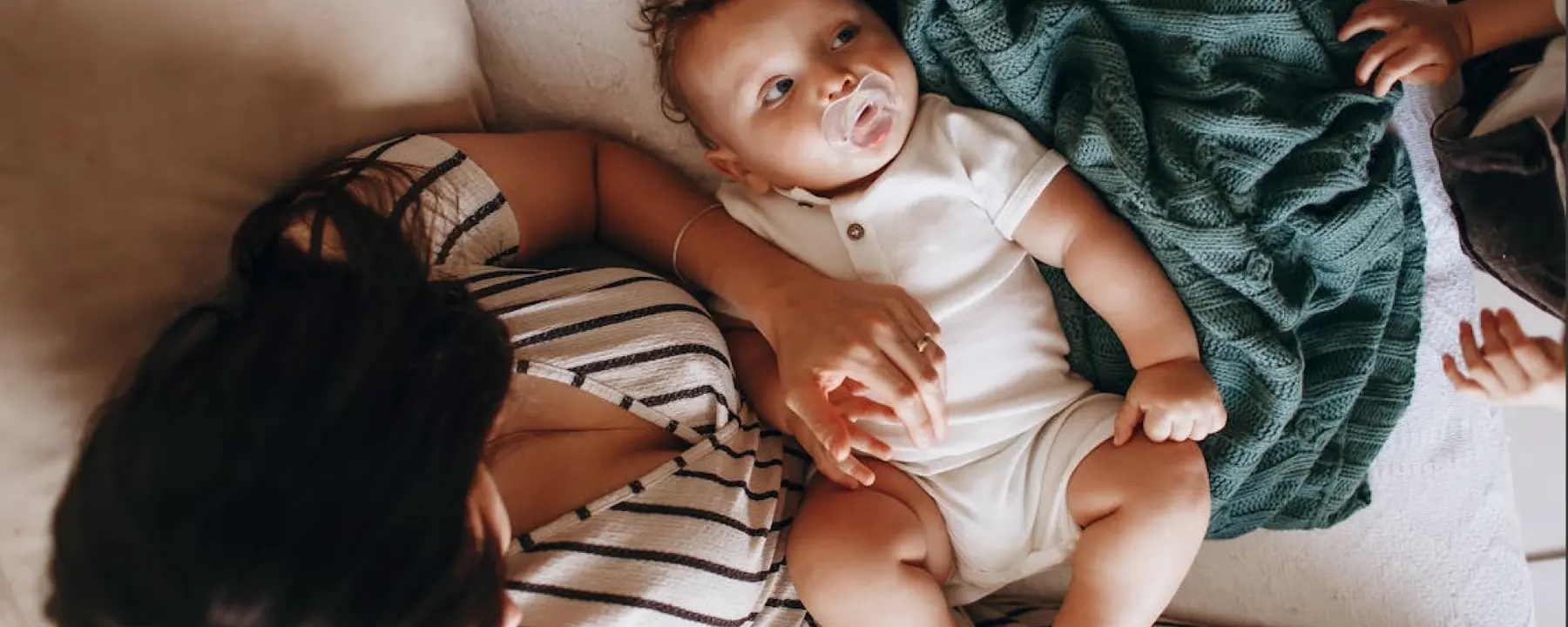 A parent resting beside their baby