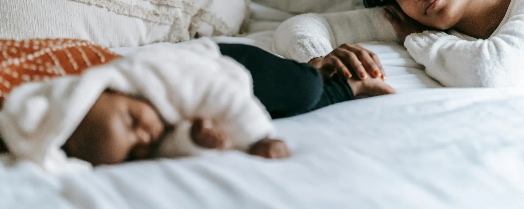 A mother watching over her sleeping newborn